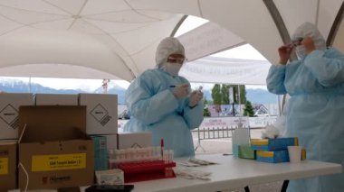 Almaty / Kazakistan: Sağlık görevlileri, bölge sakinlerini koronavirüs için test etmek amacıyla mobil bir istasyonda çalışıyorlar. 