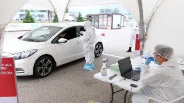Almaty / Kazakistan: Sağlık görevlileri, bölge sakinlerini koronavirüs için test etmek amacıyla mobil bir istasyonda çalışıyorlar. 