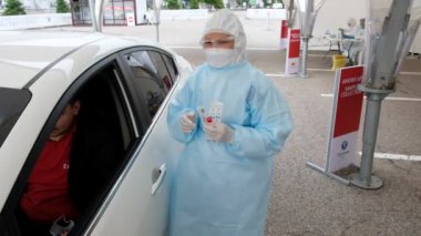 Almaty / Kazakistan: Sağlık görevlileri, bölge sakinlerini koronavirüs için test etmek amacıyla mobil bir istasyonda çalışıyorlar. 