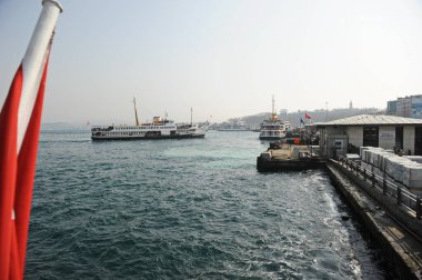 İstanbul / Türkiye - 02.28.2017: Boğazdaki tekneler ve Türkiye bayrağıyla bayrak direkleri.