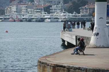 İstanbul / Türkiye - 02.28.2017: İnsanlar Boğazın kıyı şeridi yakınlarında dinleniyor.
