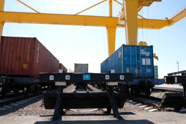 Khorgos / Kazakistan - 10.06.2018: Lojistik merkezinde konteynırlar boşaltılıyor. Makineler ve turnalar metal kutuları sürüklüyor.