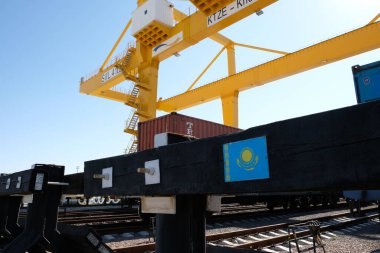 Khorgos / Kazakistan - 10.06.2018: Lojistik merkezinde konteynırlar boşaltılıyor. Makineler ve turnalar metal kutuları sürüklüyor.