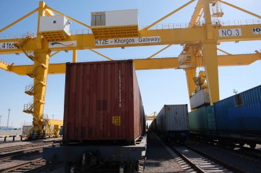 Khorgos / Kazakistan - 10.06.2018: Lojistik merkezinde konteynırlar boşaltılıyor. Makineler ve turnalar metal kutuları sürüklüyor.