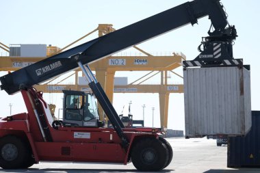 Khorgos / Kazakistan - 10.06.2018: Lojistik merkezinde konteynırlar boşaltılıyor. Makineler ve turnalar metal kutuları sürüklüyor.