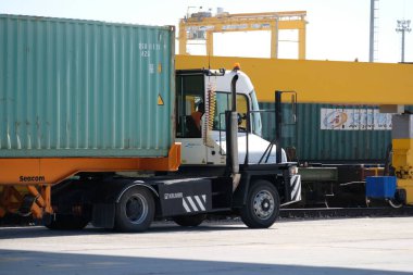 Khorgos / Kazakistan - 10.06.2018: Lojistik merkezinde konteynırlar boşaltılıyor. Makineler ve turnalar metal kutuları sürüklüyor.