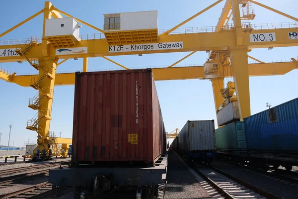 Khorgos / Kazakistan - 10.06.2018: Lojistik merkezinde konteynırlar boşaltılıyor. Makineler ve turnalar metal kutuları sürüklüyor.