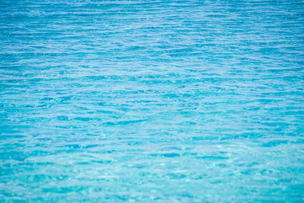 Primer plano de agua azul brillante con superficie de olas en la piscina . — Foto de Stock