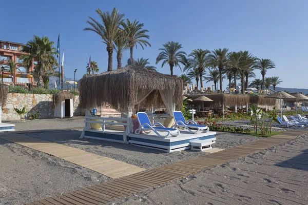 Platz am Strand mit Liegestühlen und einem Pavillon mit Strohdach — Stockfoto