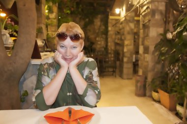 Olgun bir kadın restoranda bir emir bekliyor