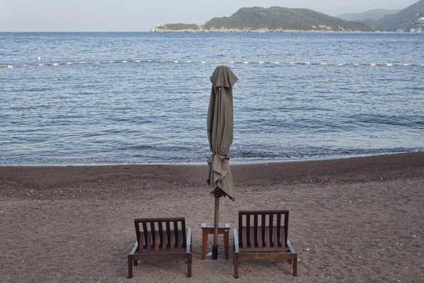 İki şezlong ve şemsiye ile küçük tablo