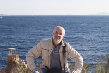 Olgun Yaş bir adam sahilde kırmızı Se arka plan üzerinde