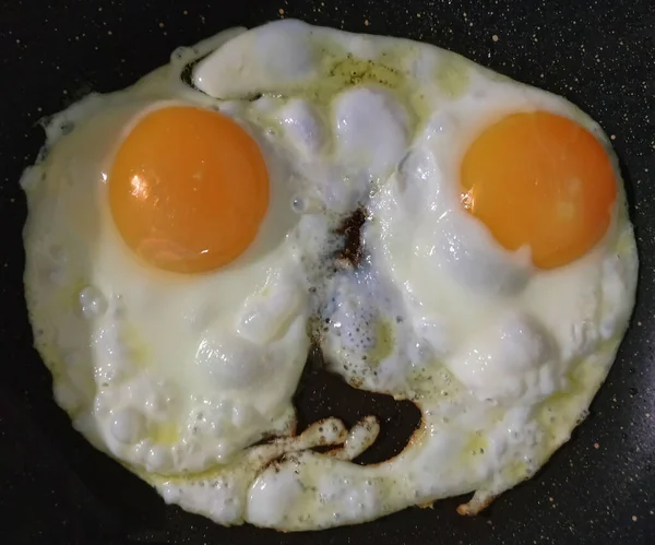 一个由两个鸡蛋组成的煎蛋放在锅里煎 有趣的情绪形态 — 图库照片