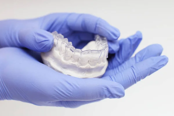 Крупный план индивидуального подноса зубов ортодонтическая стоматологическая тема. В руках невидимые брекеты — стоковое фото