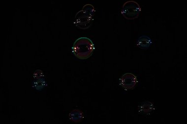 Gökkuşağı sabun köpüğü karanlık bir arka plan üzerinde.