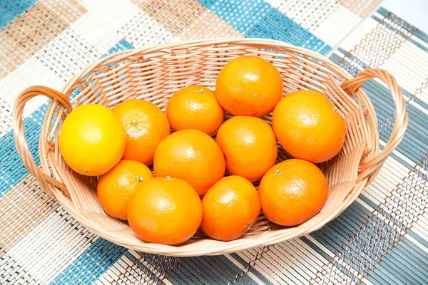 Ahşap bir masa üzerinde bir sepet içinde bazı mandalina