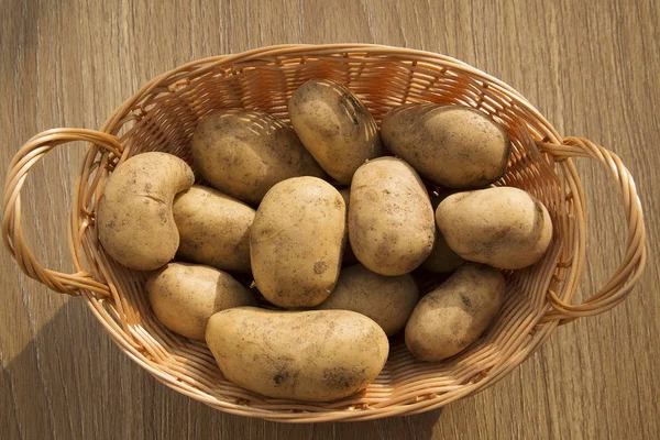 生土豆放在木制桌子上的篮子里 — 图库照片