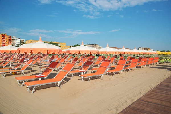 Оранжевые зонтики и шезлонги на пляже Римини — стоковое фото