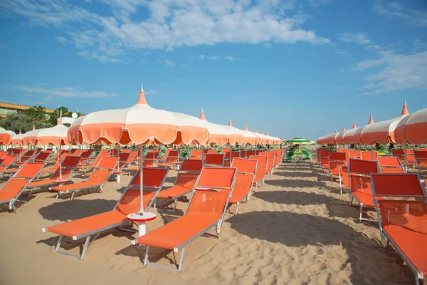 Sombrillas naranjas y chaise lounges en la playa de Rimini en Ella — Foto de Stock