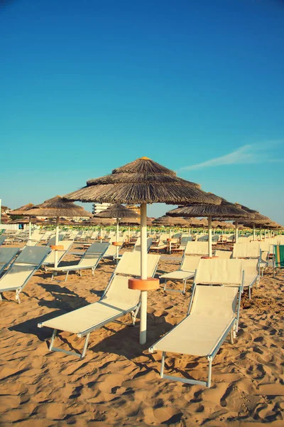 Umbrellas and chaise lounges on the beach of Rimini in Italy - — Stock Photo, Image