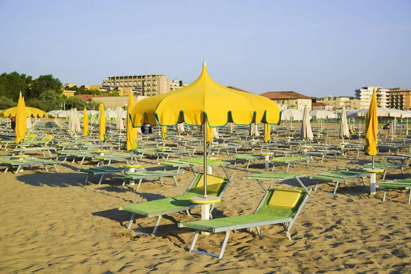 黄色い傘とイタリアのリミニのビーチの chaise のラウンジ — ストック写真