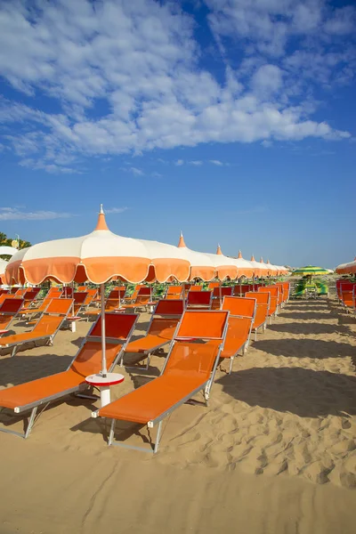 Oranje parasols en ligstoelen op het strand van Rimini in Italië — Stockfoto