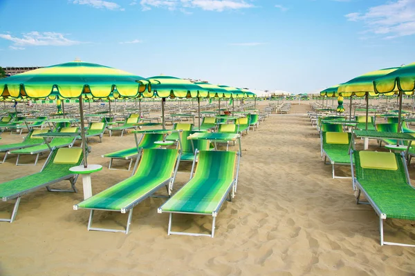 Green umbrellas and chaise lounges on the beach of Rimini in Italy — Stock Photo, Image