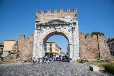 Rimini, İtalya - 21 Haziran 2017: Kimliği belirsiz kişi yürüyüş altında Augustus Arch - antik Romanesk kapısı ve tarihsel dönüm noktası, Rimini, İtalya.