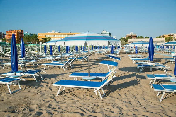 Parasols en ligstoelen op het strand van Rimini in Italië — Stockfoto