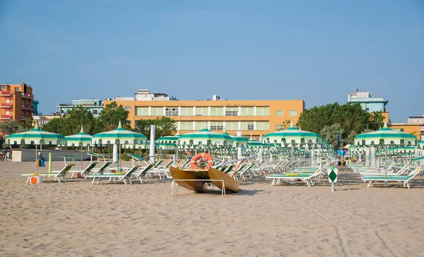 Groene parasols en ligstoelen op het strand van Rimini in Italië — Stockfoto