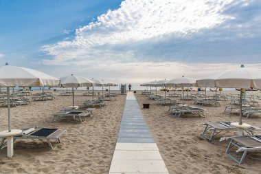 Sabah sahilde Rimini, İtalya. Yaz sahilde güneş ve chaise Lounge üzerinden şemsiye.