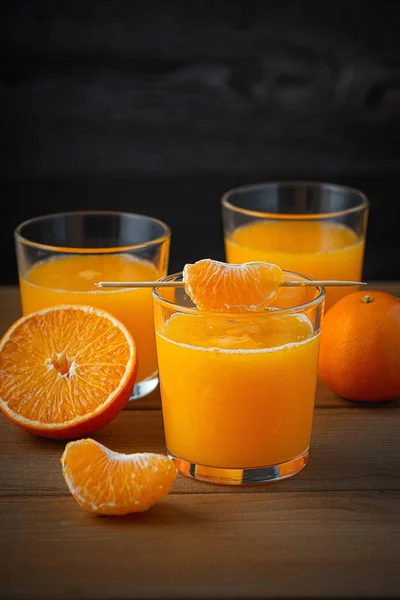 Jugo fresco de mandarina sobre una mesa de madera marrón . — Foto de Stock