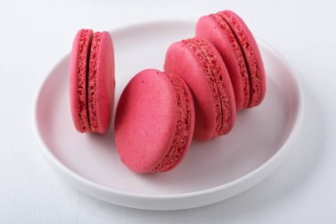 Beyaz tabakta pembe badem kurabiyeleri.