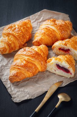 Siyah ahşap bir masada taze kruvasanlar..