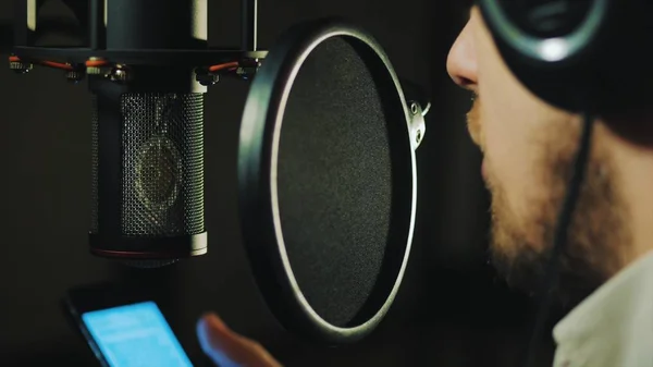 Een man zingt een lied in een opnamestudio. — Stockfoto