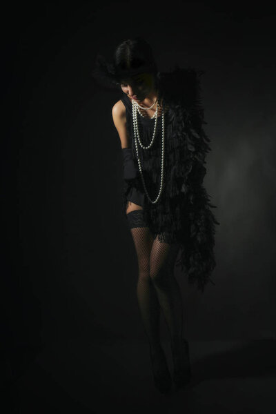 Portrait of a beautiful young woman in style of the great Gatsby of the 20s. Vintage clothing and jewelry
