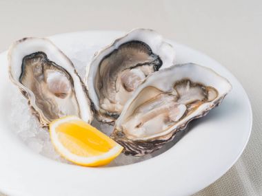 Restoranda beyaz tabakta limonlu taze istiridye