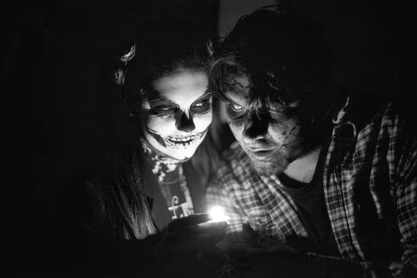 Uma menina e um homem na forma de um esqueleto durante um dia das bruxas — Fotografia de Stock