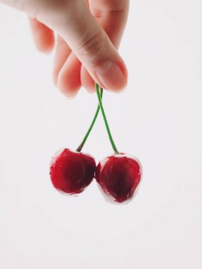 Beyaz arka plan üzerinde izole kadın el kiraz