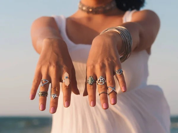 Fermer les mains avec des accessoires boho gitane argent. Femme debout sur la plage en été près de la mer . — Photo