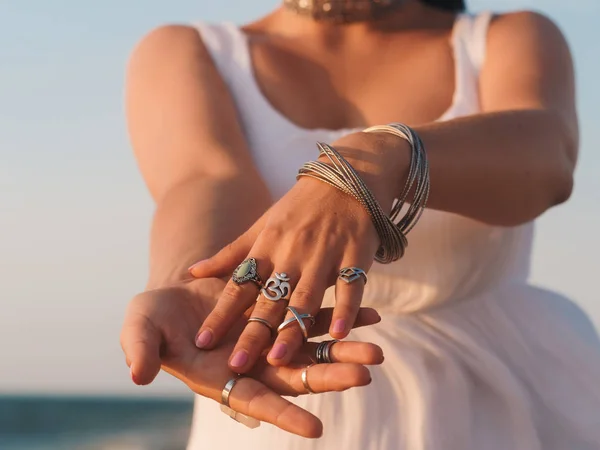 Fermer les mains avec des accessoires boho gitane argent. Femme debout sur la plage en été près de la mer . — Photo