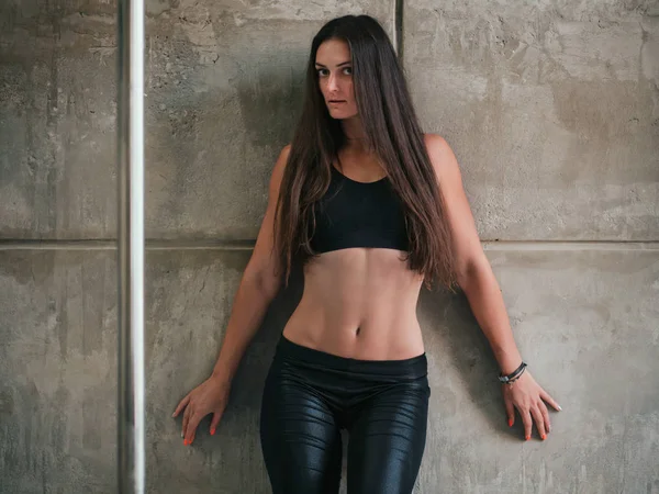 Сексуальная молодая женщина с худым телом. Девушка позирует на серой стене в студии. Танцовщица с длинными волосами. Привлекательная леди . — стоковое фото
