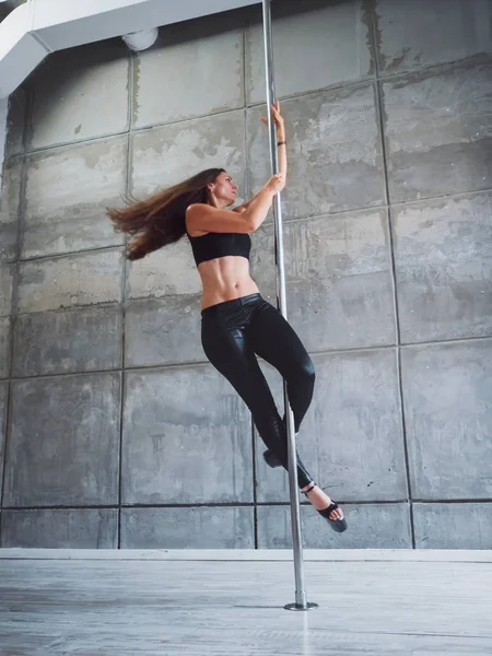 Genç seksi kadın kutup dans gri iç ince. Güzel, çekici kız kutup dans performans. Endüstriyel beton arka plan ile vurdu. Bayan iyi rakam pilon üzerinde dans ile