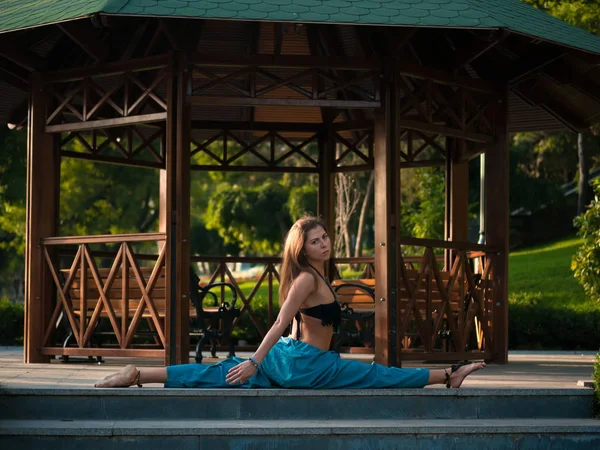 Yoga, Manhã com mulher vestindo calças alladin, belo modelo de cuidados de saúde mostrar ioga, saudável esbelto é sorriso no jardim, meditação de ioga menina, fundo de alcova de madeira — Fotografia de Stock