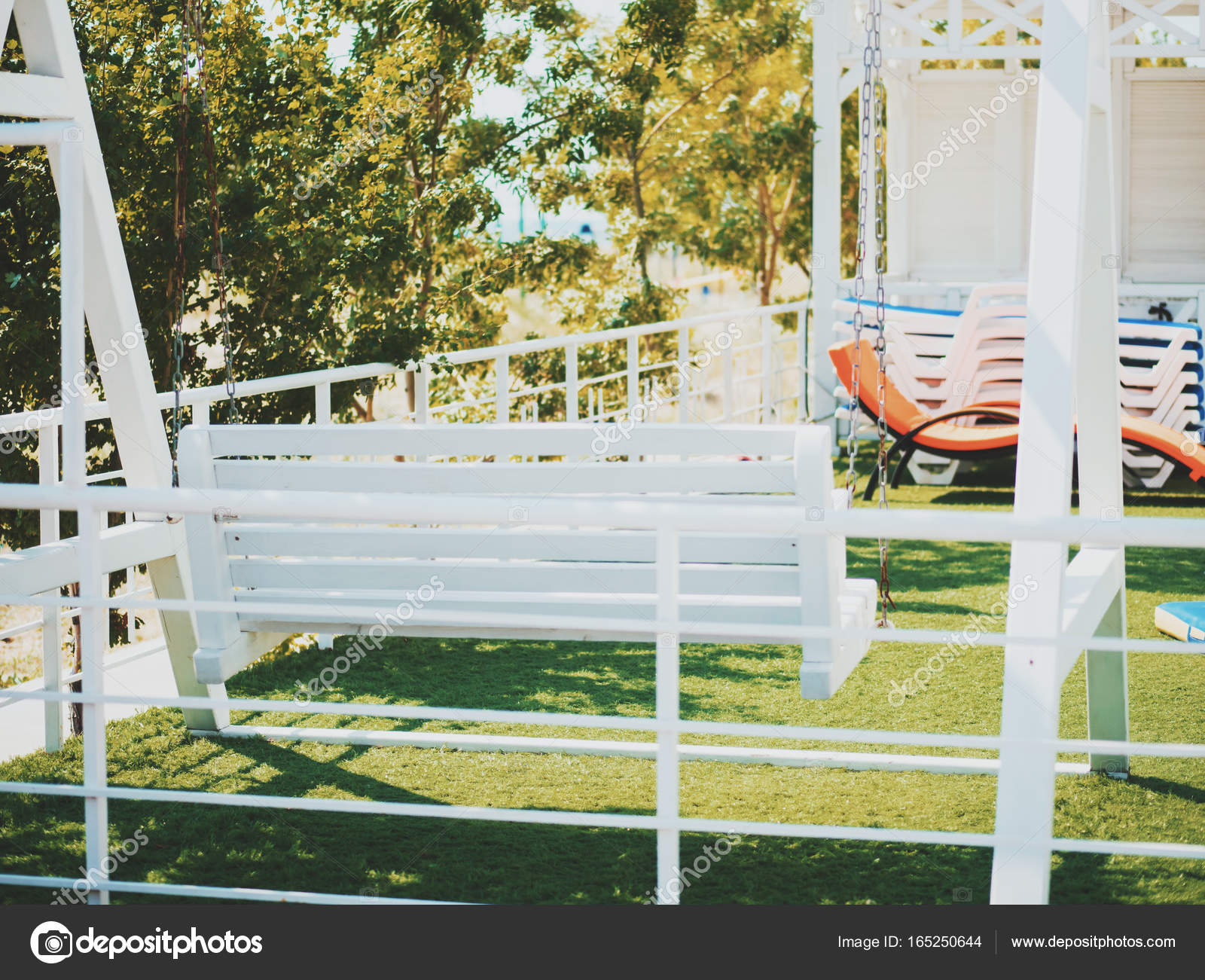 White Wooden Swinging Bench In The Garden Stock Photo