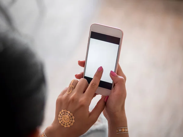 Kadın evde smartphone ile. Taşınabilir aygıt kullanarak flash dövmeli genç kız elinde. — Stok fotoğraf