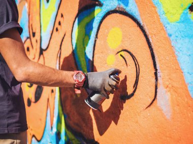 Sokak duvar grafiti sanatçısı resim. Erkek el aerosol püskürtülen ilaç şişe renkli boya, kentsel açık havada sanat kavramı ile püskürtme ile.