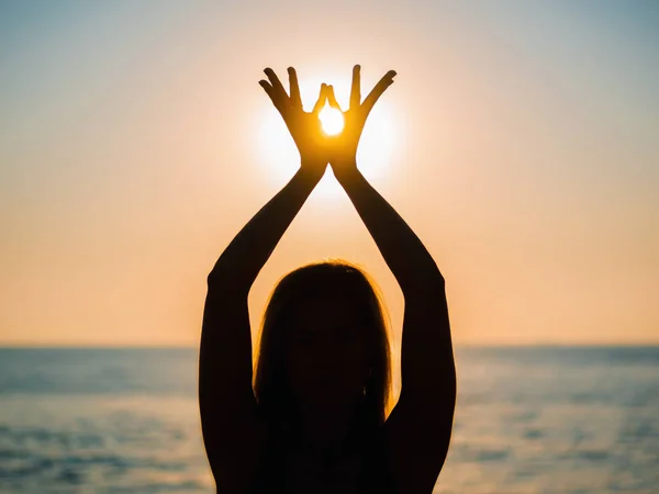 Dames handen symboliseert gebed en dankbaarheid. Mudra. Yoga concept. Silhouet van de vrouw handen op de achtergrond van de zon. Mooie scène — Stockfoto