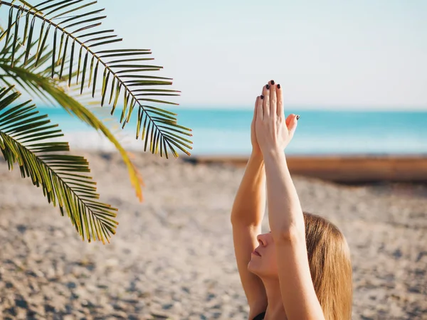 Reggel jóga lótusz póz trópusi tengerparton tree a tenyerével a gyönyörű fiatal nő. — Stock Fotó