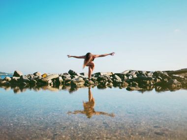 Pratik yoga deniz suyu, göl veya nehir mayo genç beyaz kadın. Güzel yansıması. Karmaşık asanas, denge. Fitness, spor, yoga ve sağlıklı yaşam konsepti.